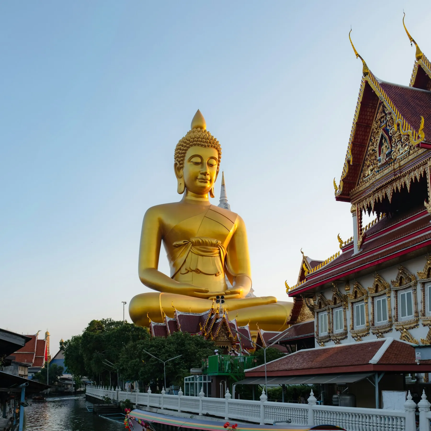 The golden Buddha at Wat Paknam above a Bangkok canal and longtail boats