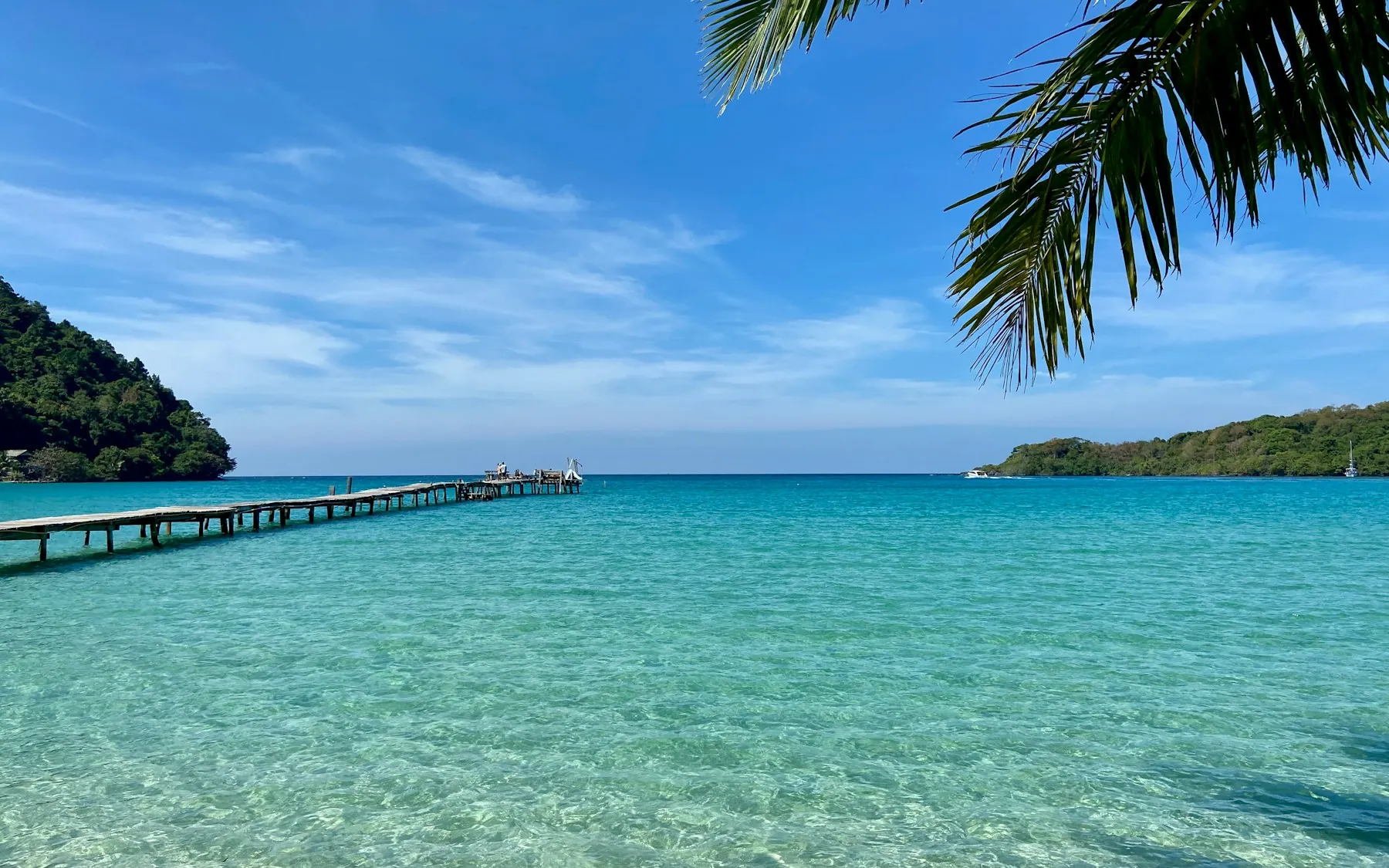 A wooden pier stretches over clear turquoise water at Koh Kood