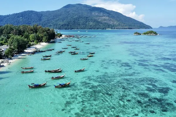 Longtail boats off Koh Lipe, with the mountainous Koh Adang shoreline beyond