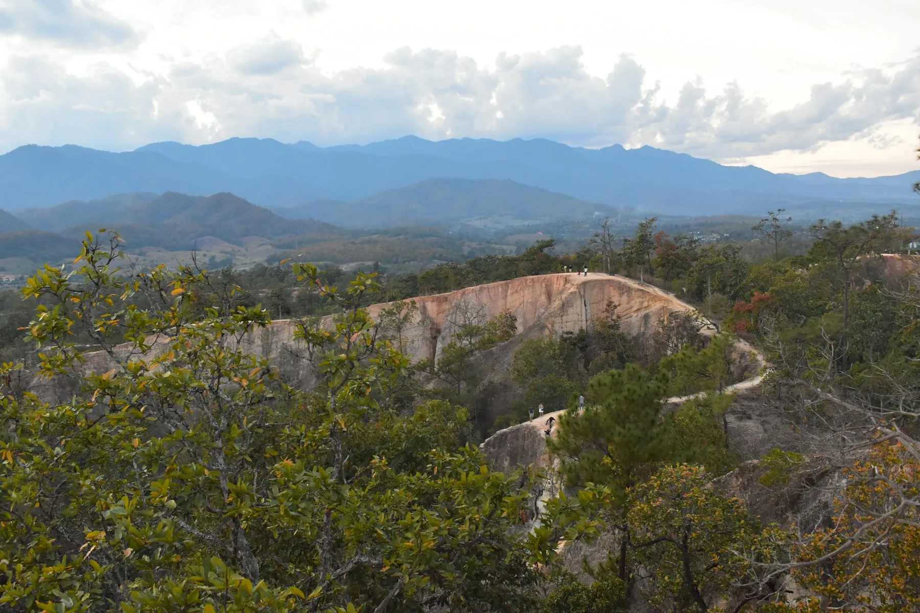 The eroded ridges of Pai Canyon with mountains beyond