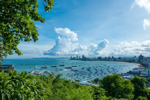 Pattaya Bay with boats, a curved beach and the city skyline seen from Pattaya View Point