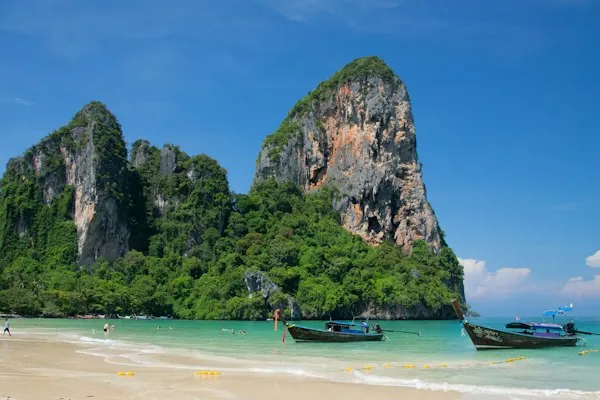 Longtail boats on Railay Beach beneath its distinctive limestone cliffs